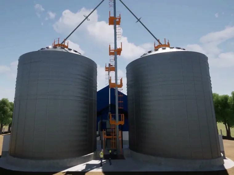 Dois silos metálicos de grãos com elevador de canecas e plataformas de acesso